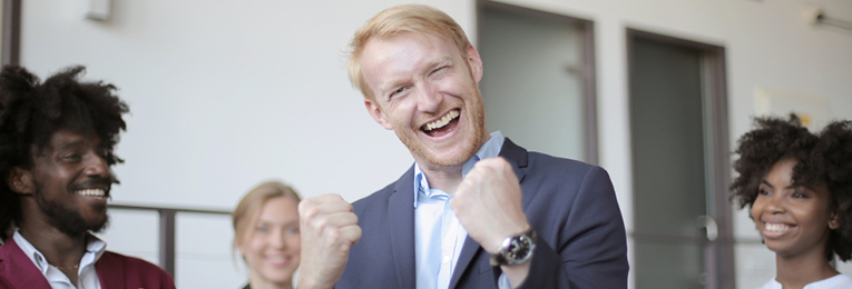 An individual raises both fists in the air, locked together in a gesture of celebration.